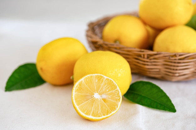 Photo group of whole and cut organic fresh lemon in wood basket on white background