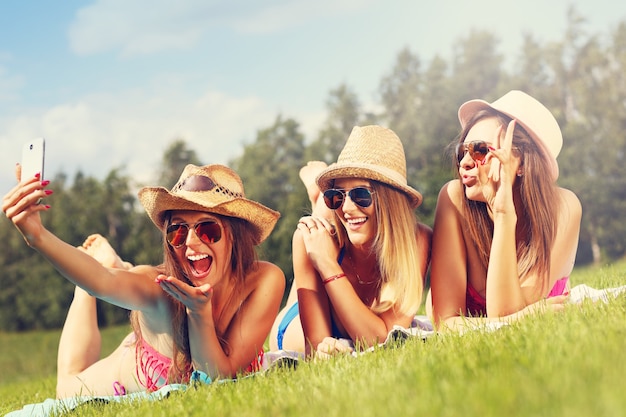 a group of women in bikin taking selfie outdoors