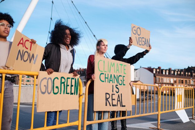 A group of women behind fences protesting against climate\
change with placards.