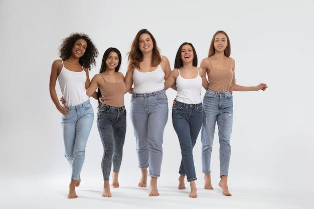 Group of women with different body types on light background