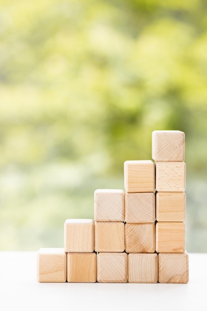 Group of wooden cube block on green summer background with copy space