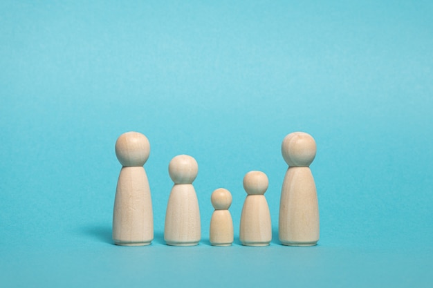 Group of wooden figures on blue background Family concept