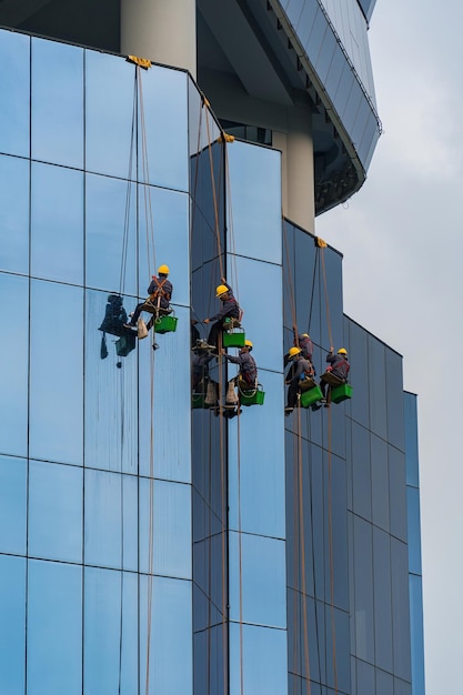 Photo group of workers cleaning glass windows service on high building or tower