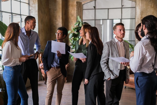 Group of workers standing analyzing the graphs on the evolution of the company