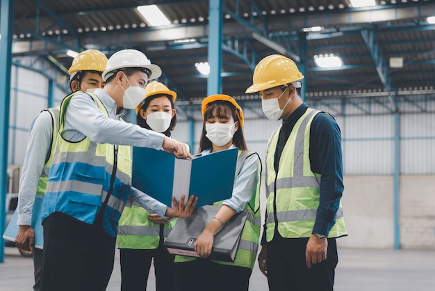 Gruppo di personale di lavoro in maschera medica facciale con riunione di sicurezza in fabbrica, concetto di sicurezza e salute sul lavoro