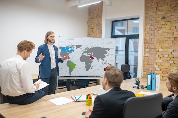 Group of young adult optimistic men in the office at presentation interested in a good mood