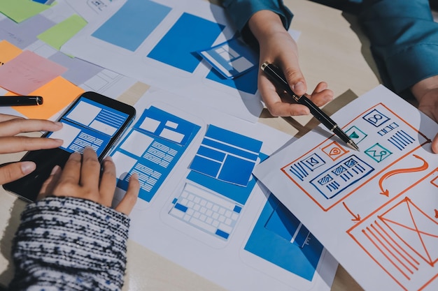 Group of young application developers analyzing uxui mobile app templates during a working meeting