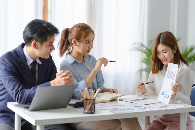 Gruppo di giovani uomini d'affari asiatici con il lavoro creativo parlano e scambiano idee condivise durante l'incontro