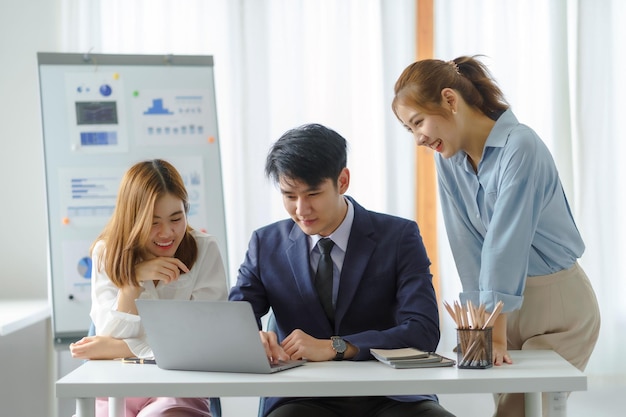 Gruppo di giovani uomini d'affari asiatici con il lavoro creativo parlano e scambiano idee condivise durante l'incontro