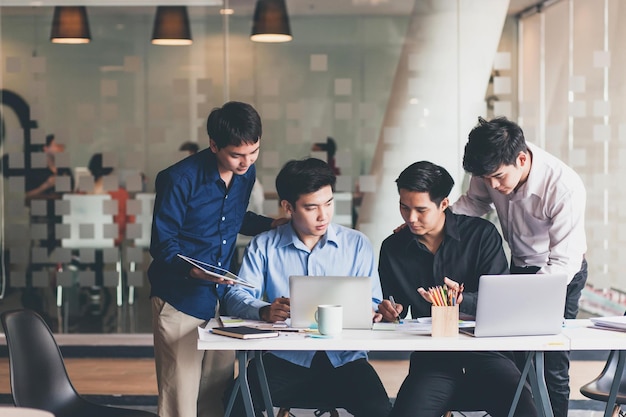 Group of young asian businessman collaborating on project in office