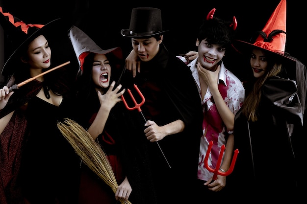 Gruppo di giovani asiatici in costume festa di halloween sul muro nero con il concetto per la festa della moda di halloween .. fantasma del costume, il male del gruppo teen thailandese.