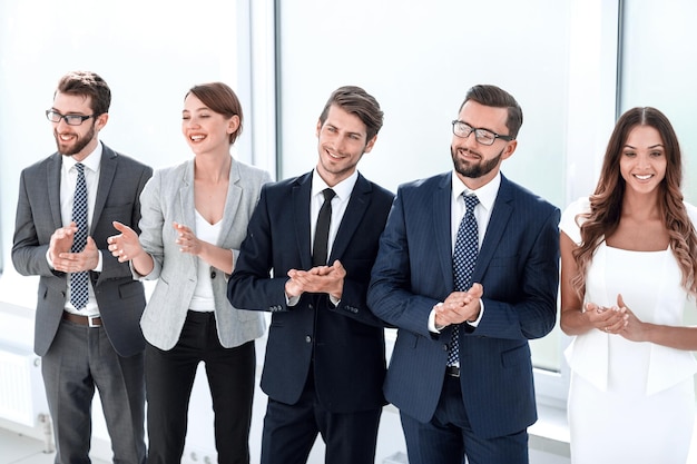 Group of young business people applauding standing in the office