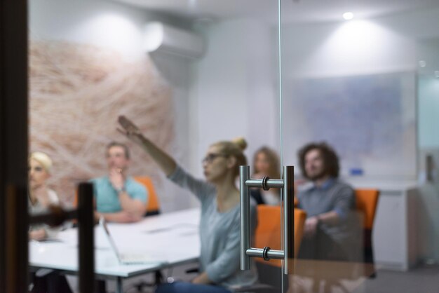 Group of a young business people discussing business plan at modern startup late night office building