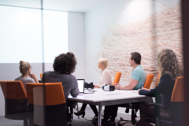 Group of a young business people discussing business plan at modern startup late night office building