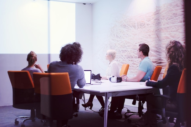 Group of a young business people discussing business plan at modern startup late night office building