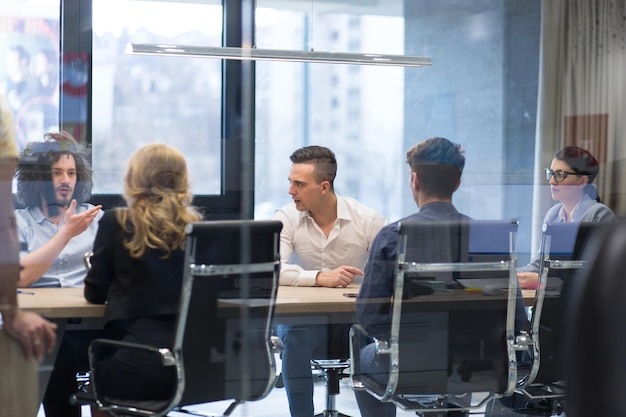 Group of a young business people discussing business plan at modern startup office building