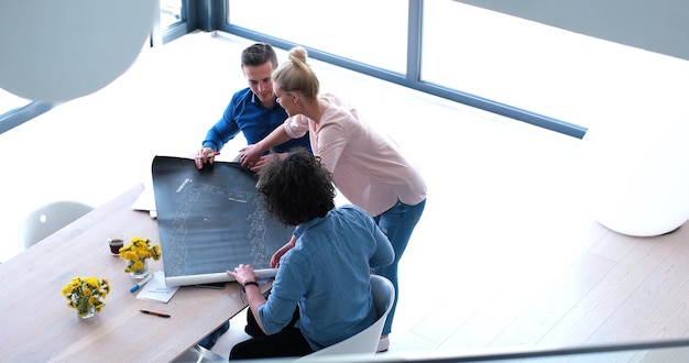 Group of a young business people discussing business plan at modern startup office building