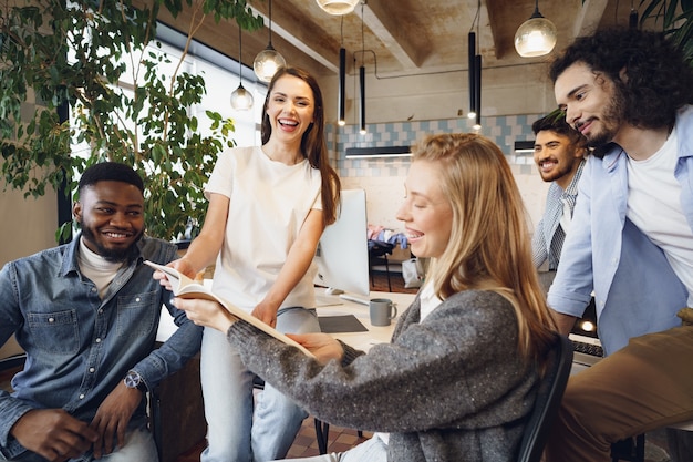 Group of young business people discussing documents during meeting in office