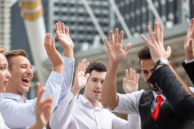 Photo group of young business people raise hand up for target achievement