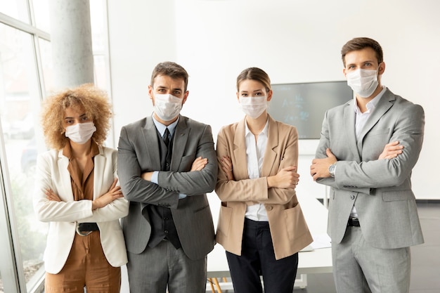 Group of young business people standing in the office and wear masks as protection from corona virus