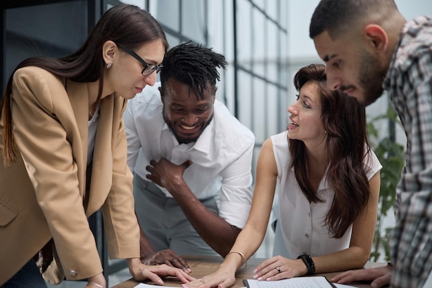 Photo group of young business people working together while standing in creative office