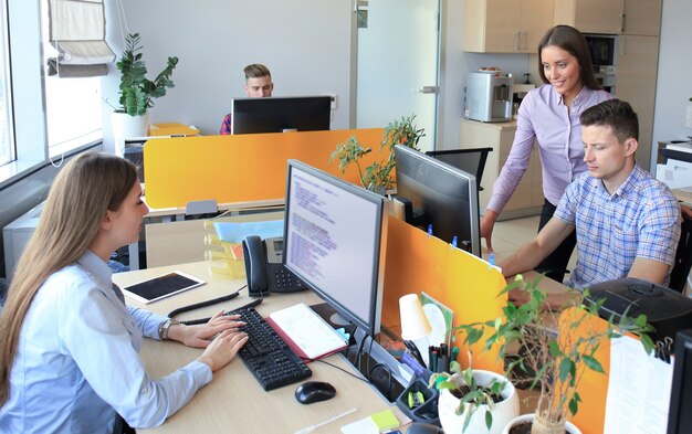 Group of young business professionals having a meeting. Diverse group of young designers smiling during a meeting at the office.