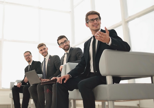 Group of young businessmen sitting in the lobby of the business\
centerphoto with copy space