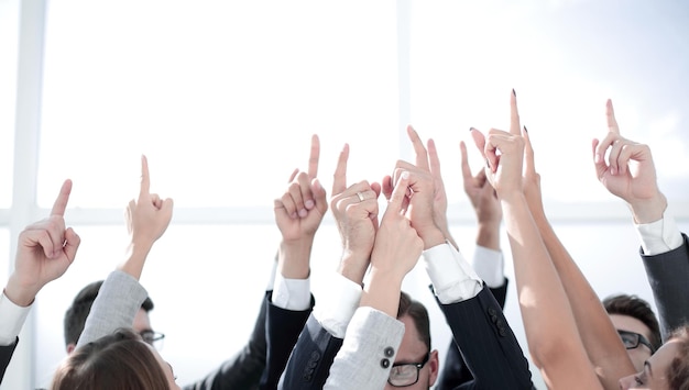 Group of young businessmen standing in a circle and pointing upphoto with copy space