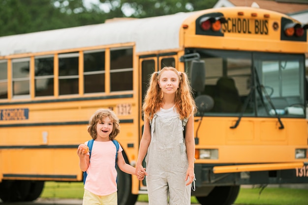 A group of young children getting on the schoolbus.