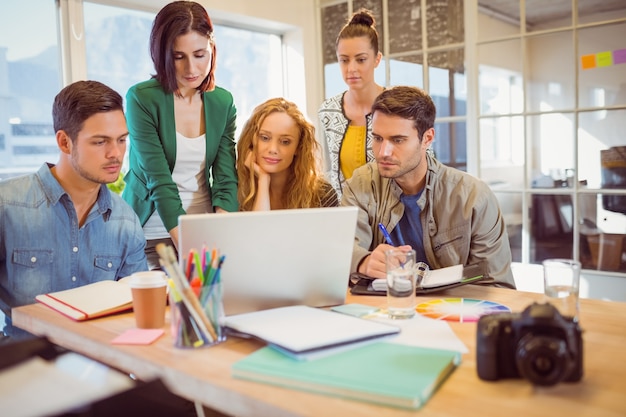 Group of young colleagues using laptop