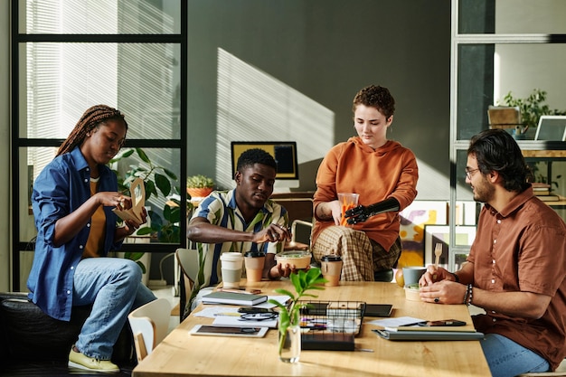 Group of young coworkers having snack and coffee for lunch