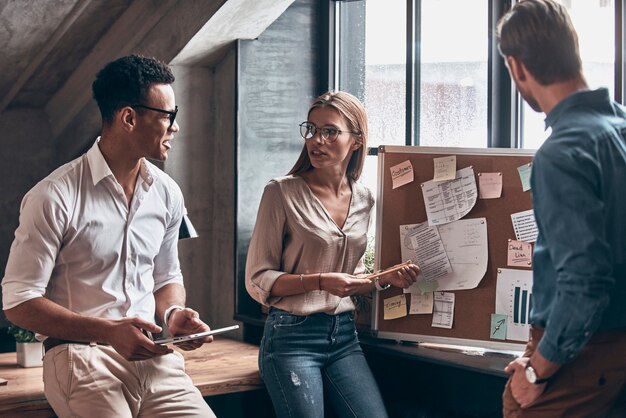 Group of young coworkers in smart casual wear having an organization meeting