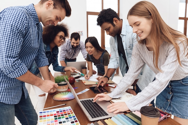 A group of young designers work together in a light office.