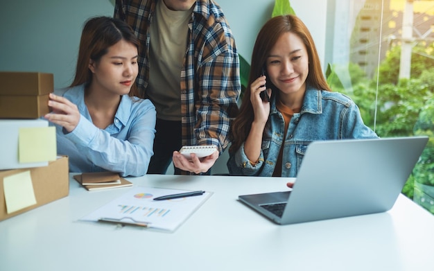 A group of young entrepreneur confirming and checking orders from customer on the phone for online shopping and delivery concept