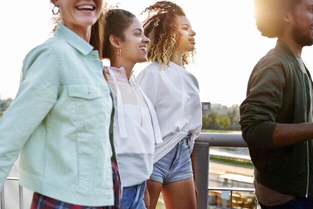 Group of young friends walking along the streets at sunset