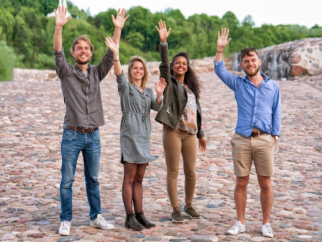 Group of young friends waving their hands as a gesture of greeting Concept