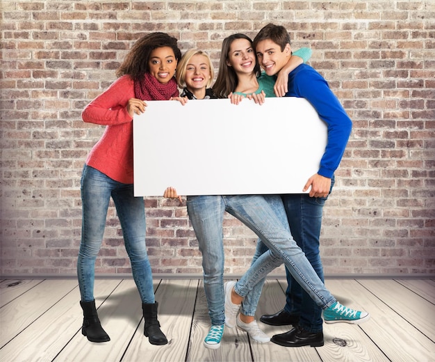 Group of young friends with advert board