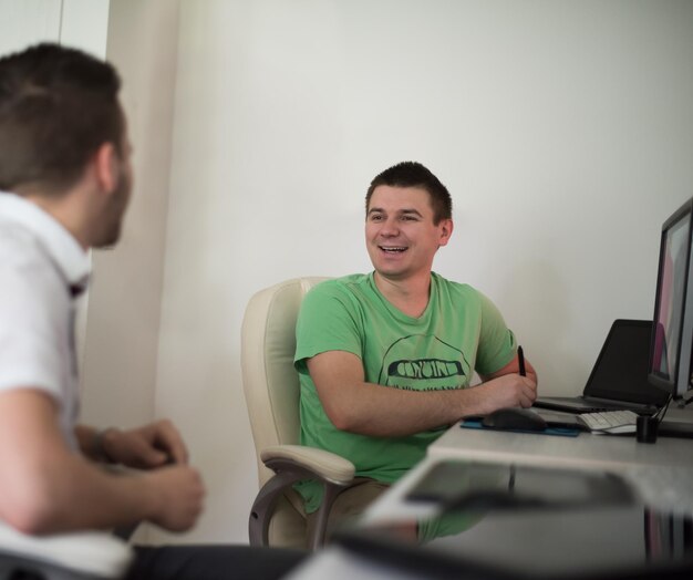 a group of young graphic designers working on a digital tablet and a computer