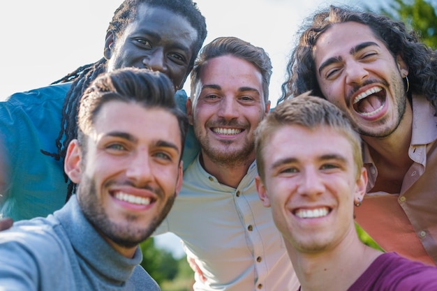 Group of young guys posing outdoors in the park while having a\
fun time focus on the guys in the back