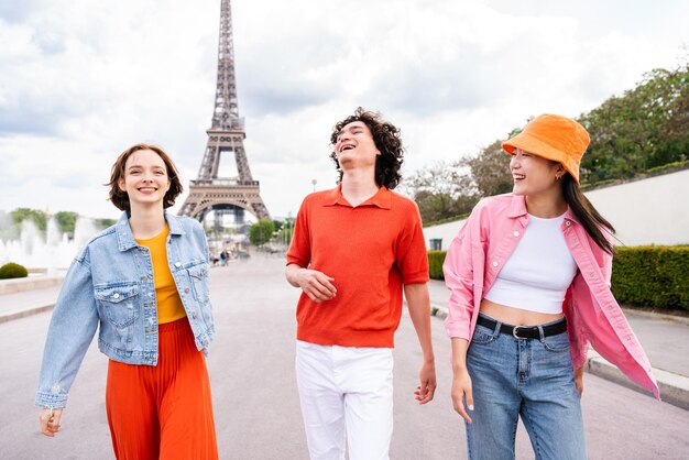 Group of young happy friends visiting Paris and Eiffel Tower