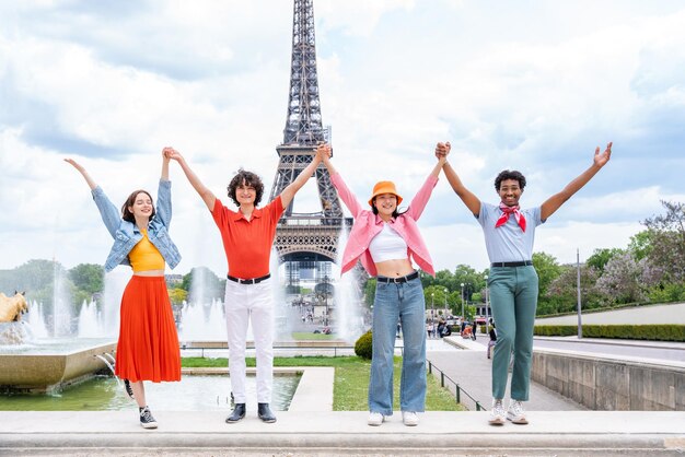 Gruppo di giovani amici felici che visitano parigi e la torre eiffel