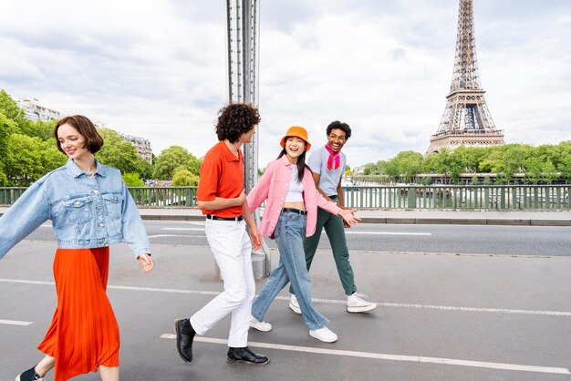 パリとエッフェル塔を訪れる若い幸せな友人のグループ