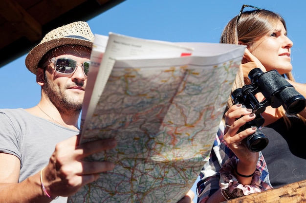 group of young hikers looking at map in the mountain