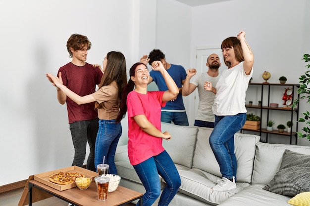 Group of young hispanic friends having party dancing at home