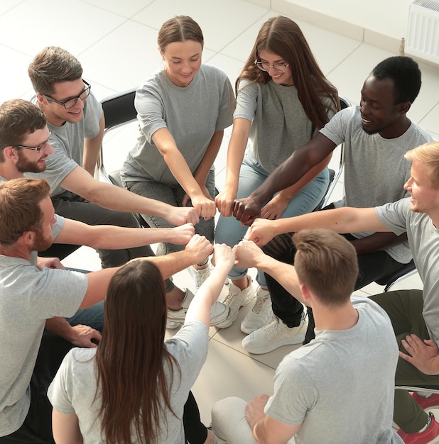 Foto gruppo di giovani persone che la pensano allo stesso modo che fanno un cerchio fuori dal loro h