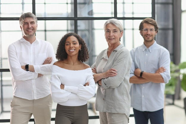 A group of young modern people in smart casual clothes studying while working in the office