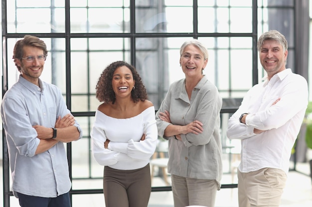 A group of young modern people in smart casual clothes studying while working in the office