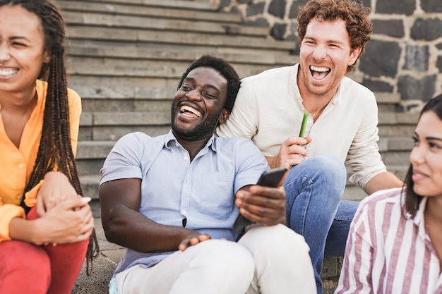 Group of young multiracial people having fun outdoor in the city