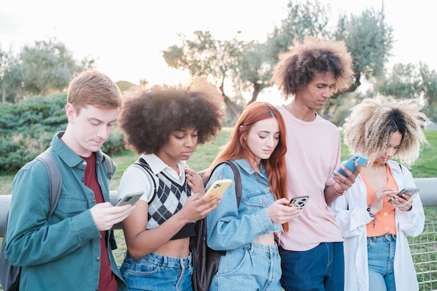 group of young people addicted to their smartphone and not sharing moments together concept vice