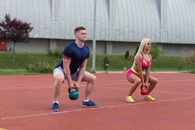 A Group Of Young People In Aerobics Class Doing A Kettle Bell Exercise Outdoor